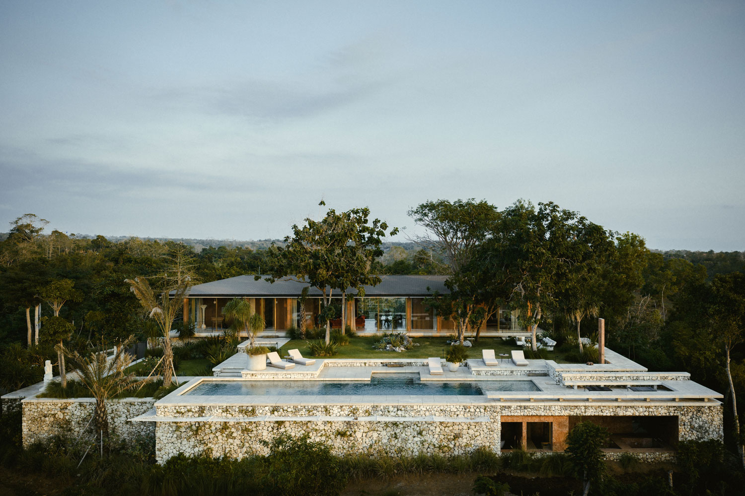 Stone terracing and a long pool frame the garden of this architect's villa in the Mentawai Islands.
